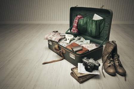 Vintage suitcase open on a wood floor in an empty room